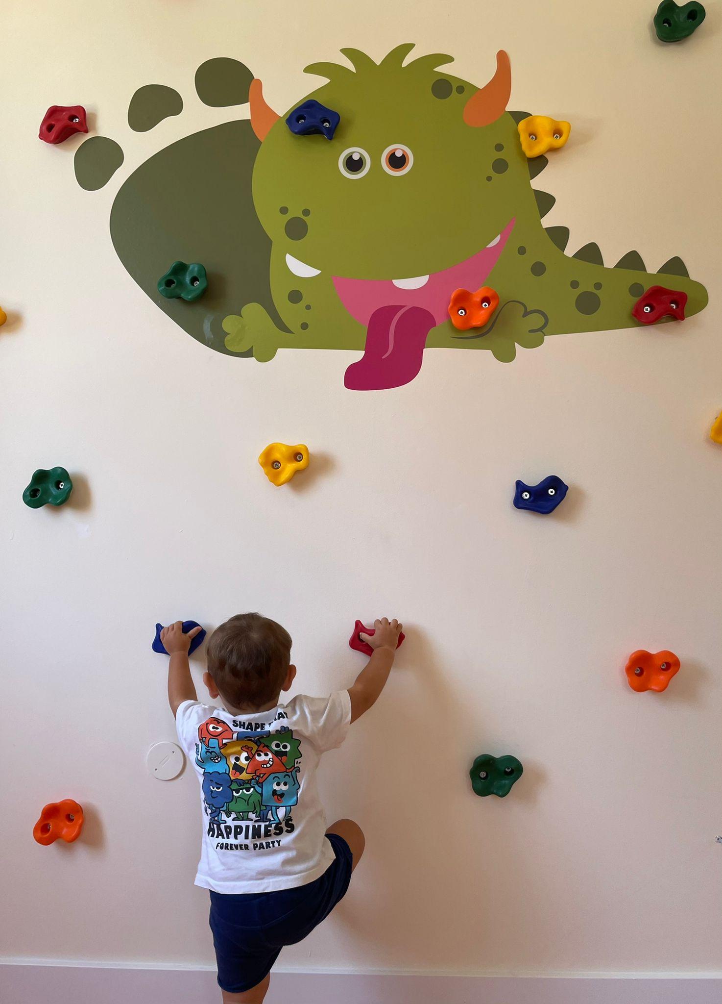 Niño escalando en una sala de terapia anda CONMiGO